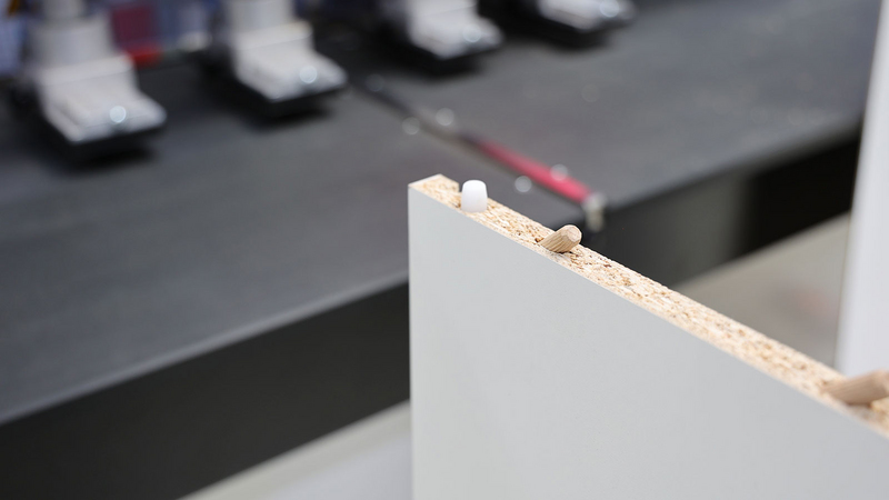 DRILLTEQ D-510 上的免工具装配型角部连接。HOMAG 展示来自 Välinge 的新方案。膨胀螺栓以接近 45 度的角度插入边缘和表面。家具部件可以轻松地相互插接，并通过“Pin-Locks”锁定。 